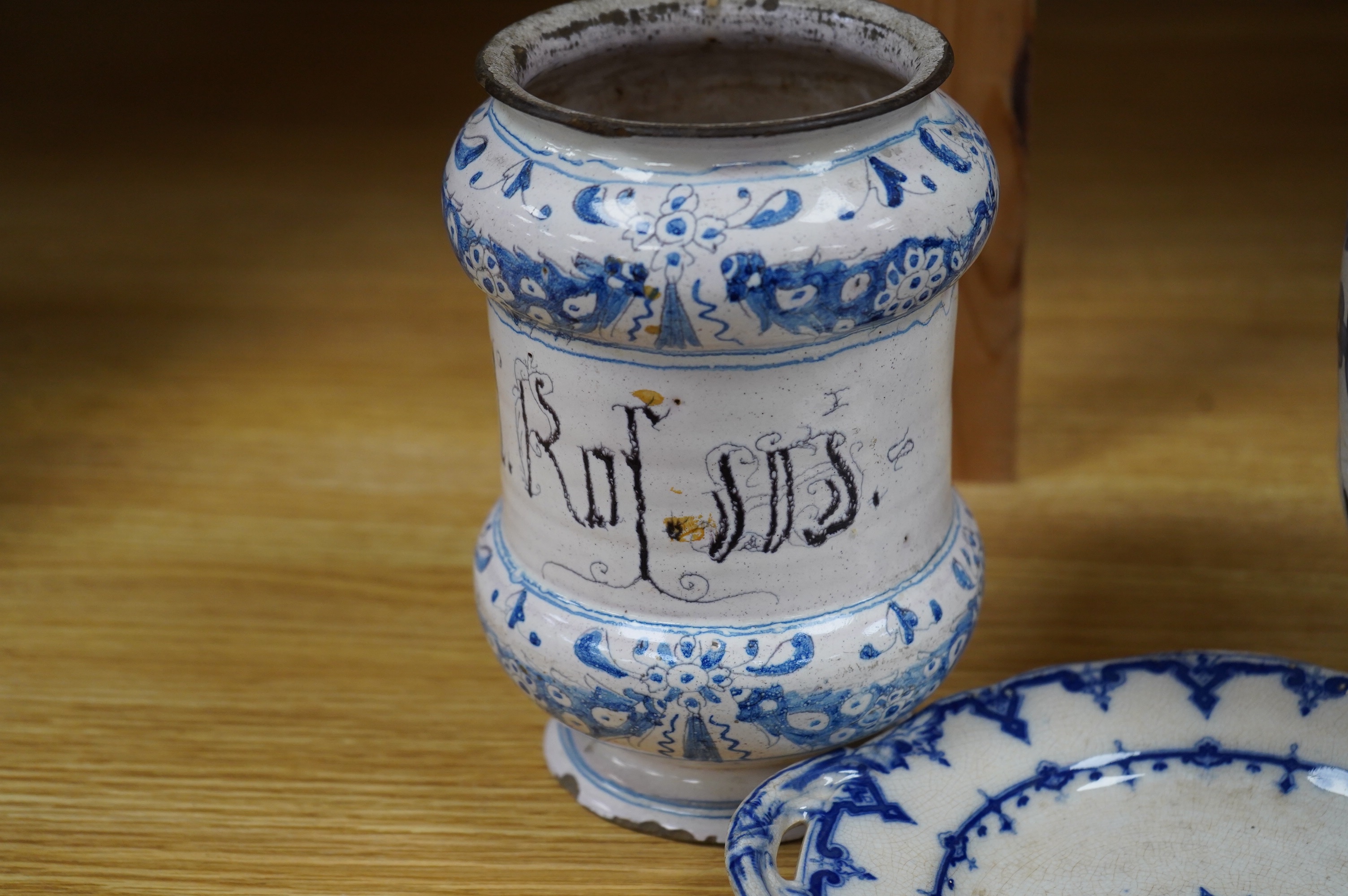 A 17th /18th century blue and white Delft apothecary jar, together with an Italian blue and white pottery drug jar and a blue and white ‘Saxon Star’ two handled dish, tallest 19cm. Condition - poor
